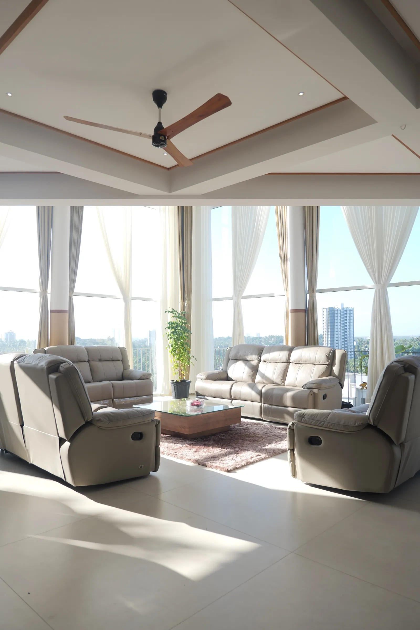 Living hall framed by floor-to-ceiling glass over the Calicut skyline